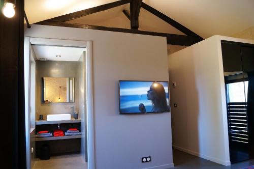 a room with a television on a wall at le mas de colongene in Faucon