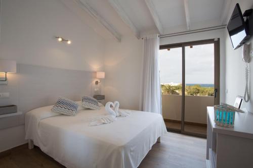 a white bedroom with a bed with towels on it at Hotel Rosamar - Emar Hotels in Es Pujols