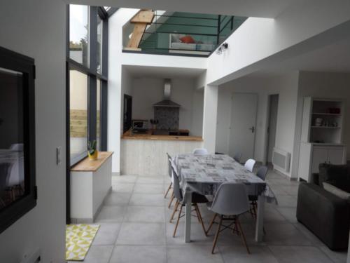 une cuisine et une salle à manger avec une table et des chaises dans l'établissement Au Coeur des Caps, à Audinghen
