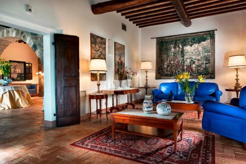 a living room with blue furniture and a painting on the wall at Relais Osteria Dell'Orcia in Bagno Vignoni