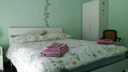 una camera da letto con un letto e asciugamani rosa di Casa Christine a Genova