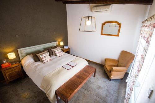 a bedroom with a large bed and a chair at Casa Lila in Mendoza