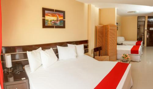 a hotel room with a large white bed with white pillows at Hotel B´liam in Tumbes