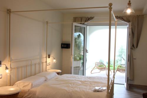 a bedroom with a canopy bed and a balcony at Oliveto in Limone sul Garda