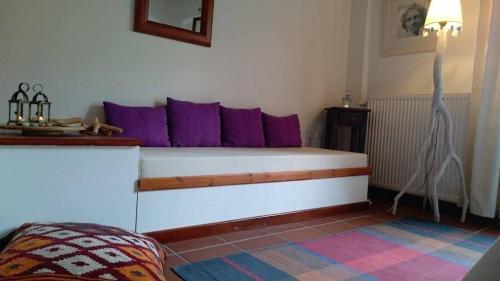 a bedroom with a bed with purple pillows at Helicon Muses Friendly Mountain B&B Guesthouse in Evangelístria