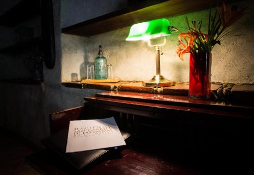 a desk with a green lamp and a paper on it at Hacienda San Gabriel de las Palmas in Amacuzac