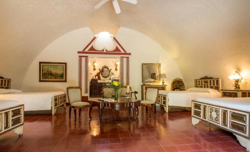 a bedroom with two beds and a table and chairs at Hacienda San Gabriel de las Palmas in Amacuzac