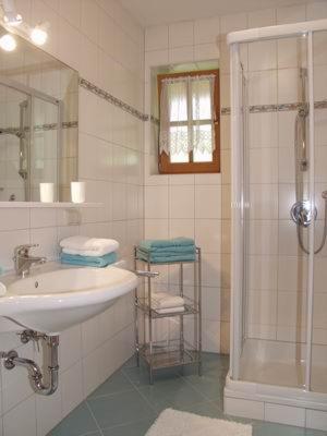 a white bathroom with a sink and a shower at Appartement Jackie Eschbacher in Wagrain