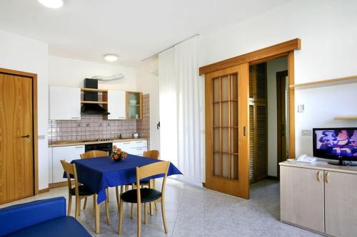 a kitchen and dining room with a blue table and chairs at Residence le Spiagge in Rimini