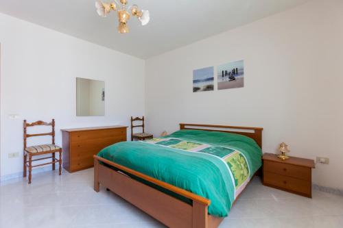 テレーゼにあるAppartamento Telese Termeのベッドルーム1室(ベッド1台、椅子2脚、シャンデリア付)