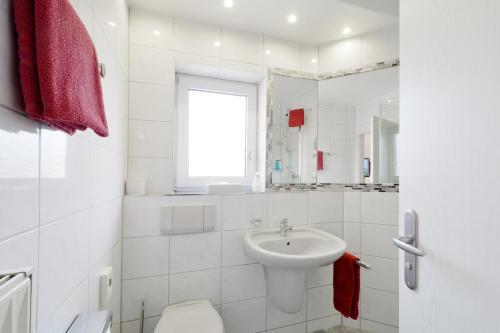 a white bathroom with a sink and a toilet at Hotel Engelhorn in Leimen