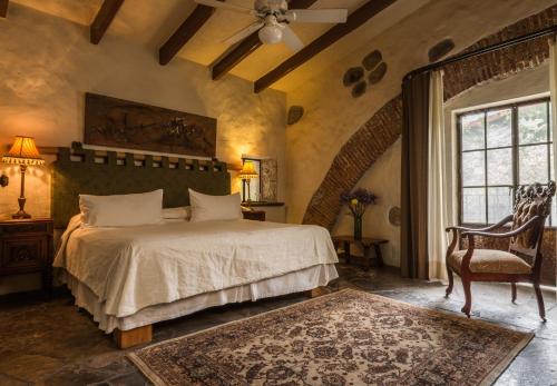 a bedroom with a bed and a chair and a window at Hacienda San Gabriel de las Palmas in Amacuzac