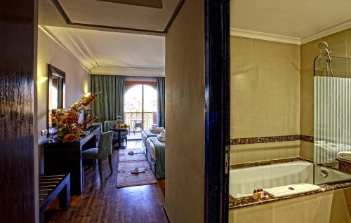 a bathroom with a tub and a living room at Palm Plaza Marrakech in Marrakech