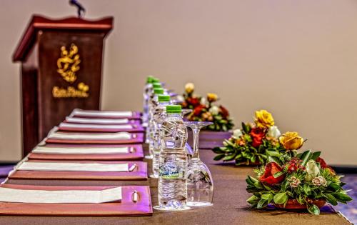 a long table with a row of glasses and flowers at Palm Plaza Marrakech in Marrakech
