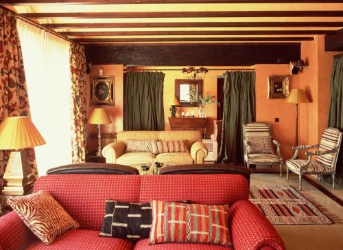 a living room with a red couch and chairs at Remanso de Gredos in Navalonguilla