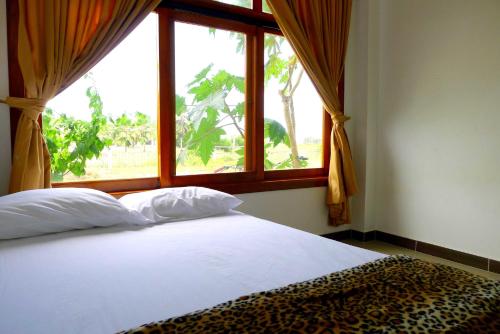 a bed in a bedroom with a large window at Hotel Sotavento in Montañita