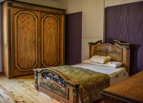 a bedroom with a bed and a large wooden cabinet at Shata Apartment - Families Only in Cairo
