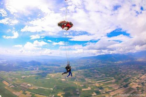 a person hanging from a parachute in the sky at Helicon Muses Friendly Mountain B&B Guesthouse in Evangelístria