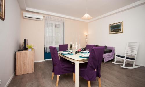a dining room with a table and purple chairs at Apartment Simone in Split