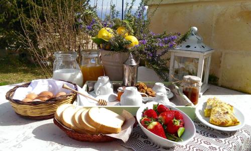 een tafel met een ontbijt van eieren, brood en fruit bij La Vallonea in Casamassella