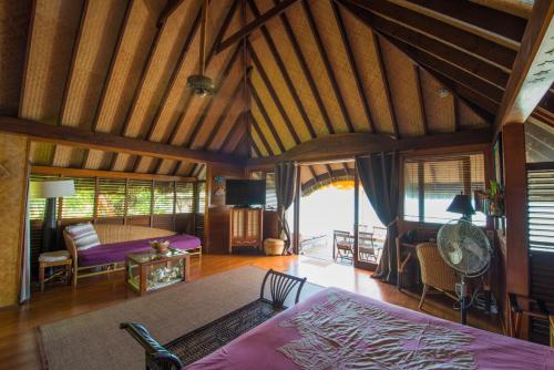 a bedroom with a bed and a living room at Bora Bora Bungalove in Bora Bora