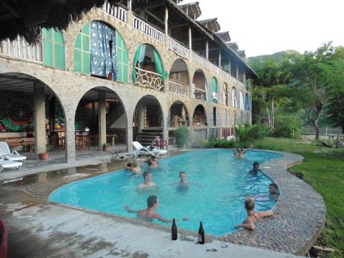 a group of people sitting in a swimming pool at Lobo Hostel - Rurrenabaque in Rurrenabaque