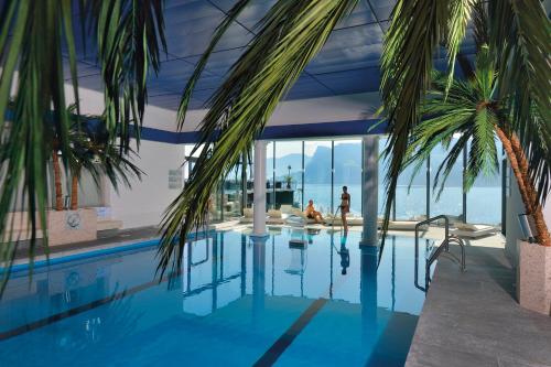 a house with a swimming pool with people in it at Seehotel Pilatus in Hergiswil