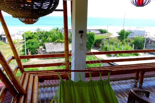 a balcony with a hammock and a view of the ocean at Hotel Sotavento in Montañita