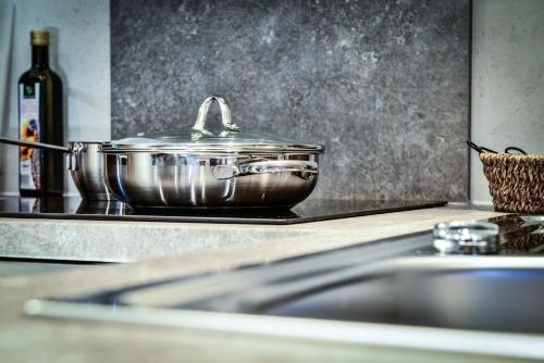 a silver pot sitting on a counter next to a sink at Sonn Alpin - Ferienwohnungen in Grän