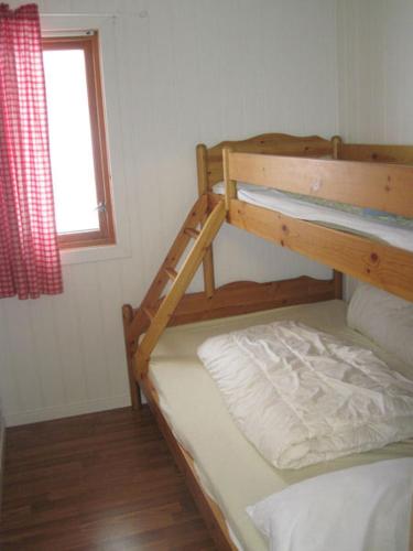 a bedroom with two bunk beds and a window at Seljestad Cottages in Skare