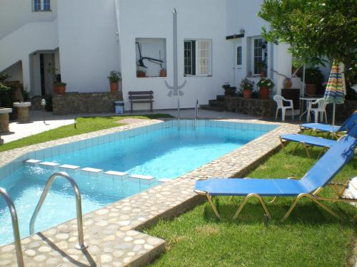 a swimming pool with a blue chair at Konaki Apartments in Maleme