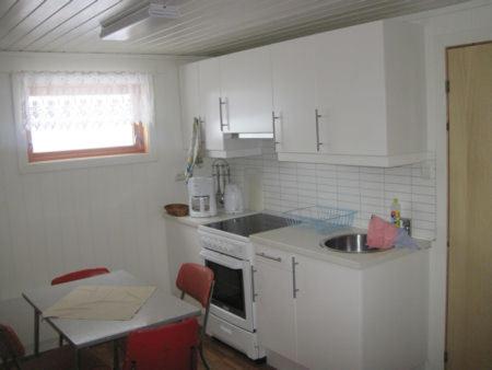 a small kitchen with a sink and a stove at Seljestad Cottages in Skare