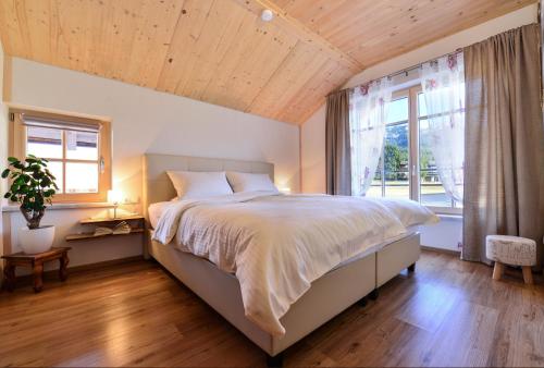 a bedroom with a large bed and a large window at Sonn Alpin - Ferienwohnungen in Grän