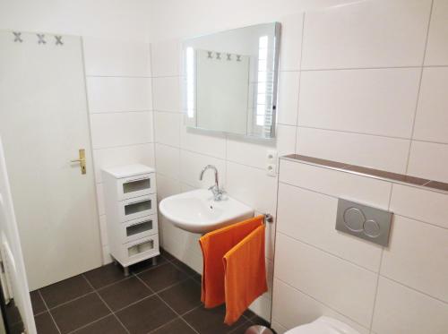 Baño blanco con lavabo y espejo en Ferienunterkunft Börner en Ehlscheid