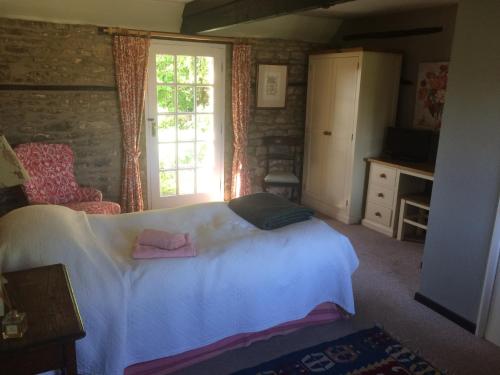 a bedroom with a white bed and a window at Mill Farm in Milton Keynes