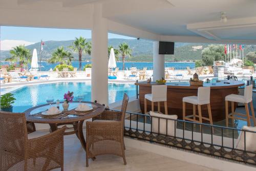 a restaurant with a pool and a table and chairs at Torbahan Hotel in Torba