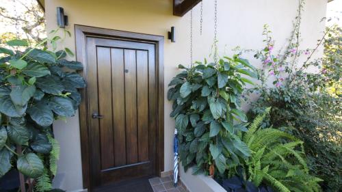 a wooden door in the side of a house with plants at The Guest Suites at Manana Madera in Boquete