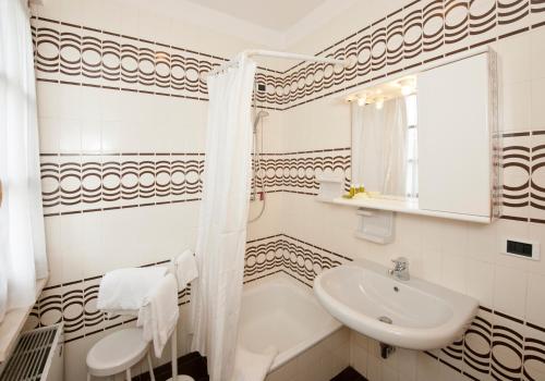 a bathroom with a sink and a tub and a toilet at Residence Alexandra Stay in Sirmione