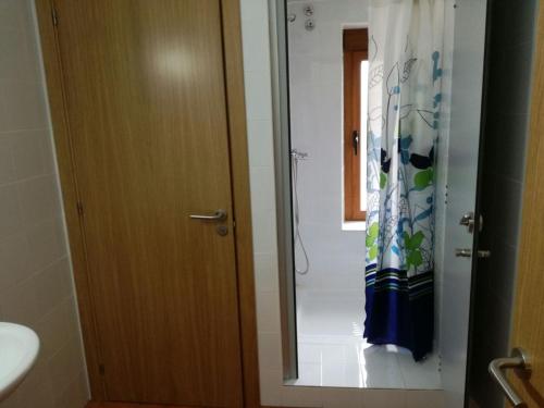 a bathroom with a shower curtain and a mirror at Albergue Vive tu Camino in Reliegos