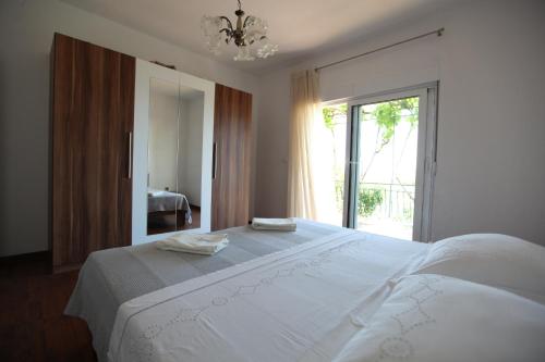 sypialnia z dużym białym łóżkiem i dużym oknem w obiekcie Apartment Marin w mieście Donji Seget