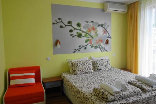 a bedroom with a bed and a red chair at Aquamarine in Sozopol