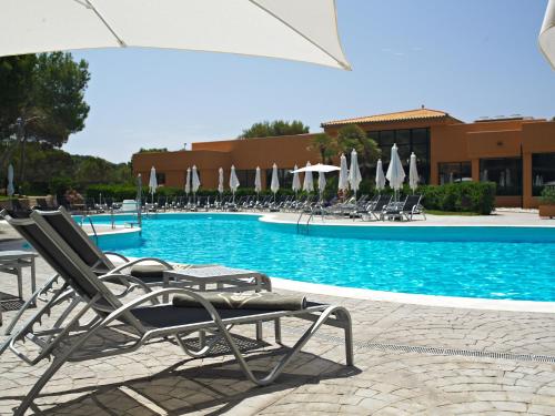 a pool with lounge chairs and umbrellas in a resort at Protur Turo Pins 4* SUP in Cala Ratjada