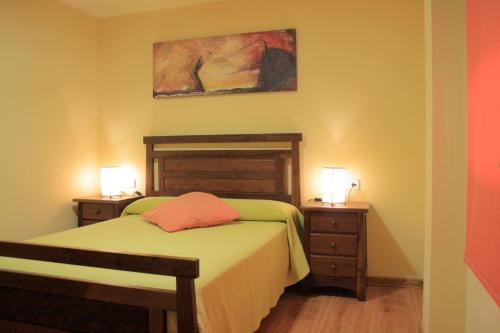 バイヨーナにあるApartamentos Ababidesのベッドルーム1室(緑のベッド1台、ナイトスタンド2台付)