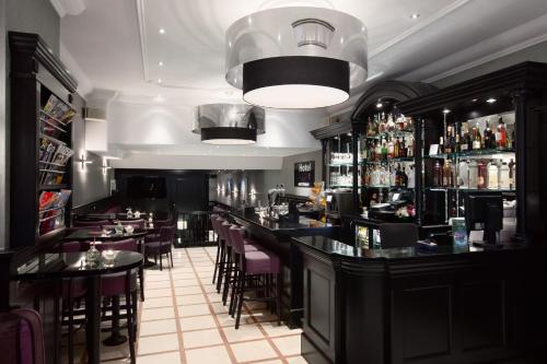 a restaurant with a bar with tables and chairs at Hotel Luxer in Amsterdam
