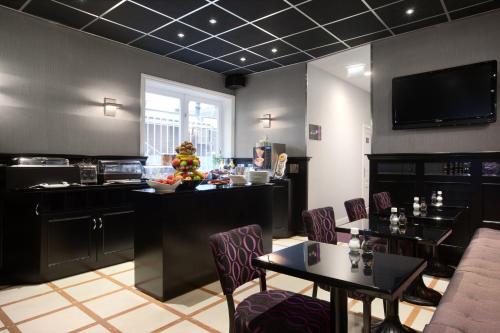 a room with tables and chairs and a kitchen at Hotel Luxer in Amsterdam