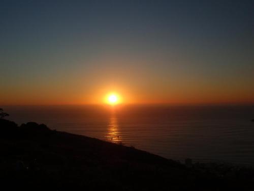 einen Sonnenuntergang über dem Meer mit der Sonne am Himmel in der Unterkunft Lala Panzi B&B in Plettenberg Bay