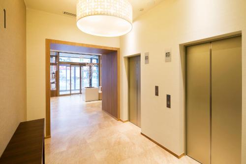 a hallway of a building with doors and a chandelier at JR-East Hotel Mets Kitakami in Kitakami