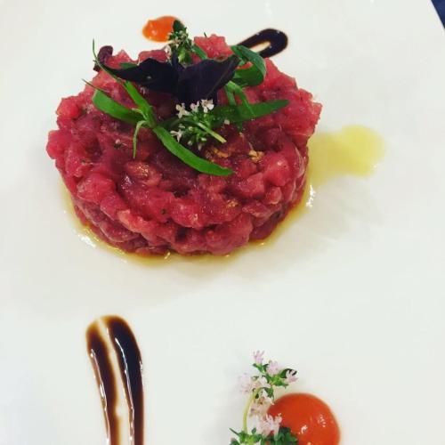 a plate of food with red sauce and greens on it at Punta Campanella Resort & Spa in Massa Lubrense