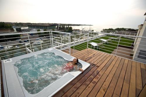 a person in a hot tub on the deck of a cruise ship at Hotel Acquadolce in Peschiera del Garda
