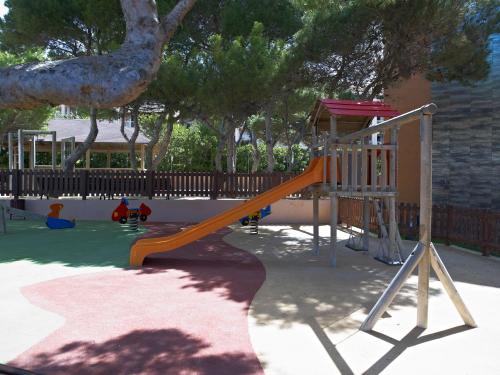 a playground with an orange slide in a park at Protur Turo Pins 4* SUP in Cala Ratjada